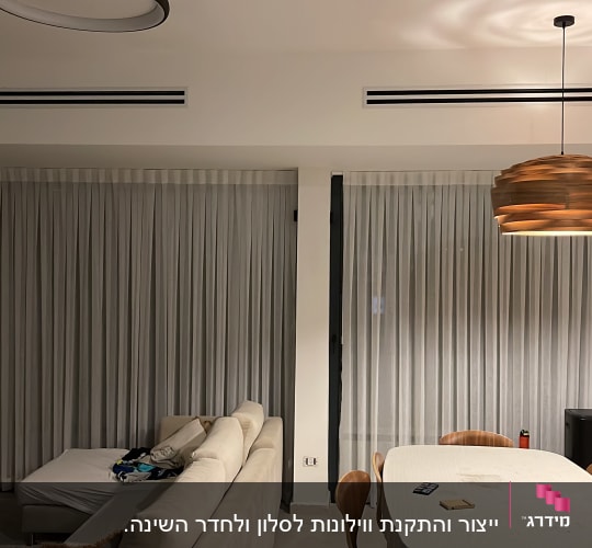 וילונות לבנים תלויים על חלונות גדולים בסלון
